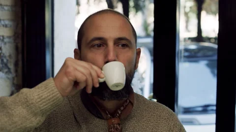 Medium shot on 4k RED camera. In a small coffee shop, a thoughtful Italian man d Stock Footage 199460358
