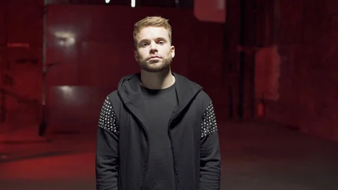 Medium shot in 4K of young handsome blond blue-eyed man wearing black t-shirt 스톡 동영상 107529330