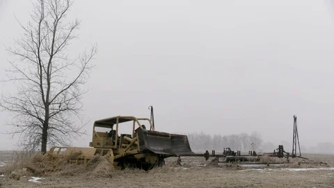 Medium shot of abandoned bulldozer in farm field winter Stock Footage 89945060