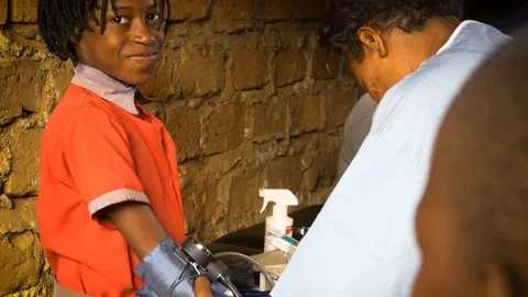 Medium shot of a african chid gets blood pressure measured, Namuwongo, Stock Footage