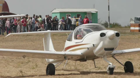Medium shot of an aircraft with the running engine with the airshow visitors on Video stock 38574035