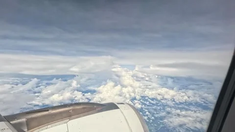 Medium shot from airplane window showing white clouds at high altitude Stock Footage 339895151