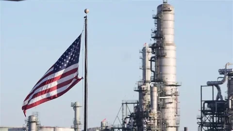 Medium shot american flag blowing in wind with power plant in background Vidéo 69153501
