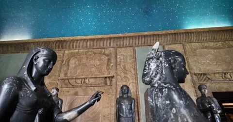 Medium shot of ancient dark stone Egyptian statues under a starry ceiling Stock-Footage 339995516