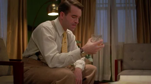 Medium shot of an angry businessman drinking liquor, 1950s, USA - Reenactment Stock Footage 245290553