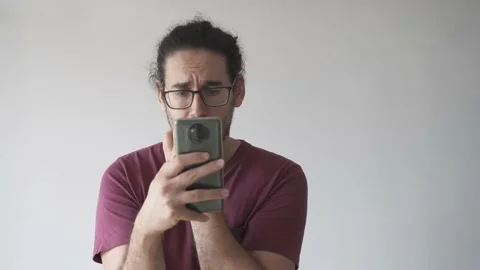 Medium shot of anxious man looking at smartphone and biting his nails Stock Footage 161551868