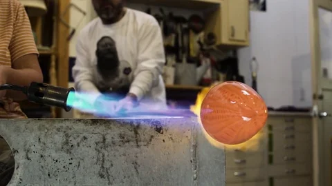 Medium shot of artisans heating glass with a blow torch 動画素材 76226875