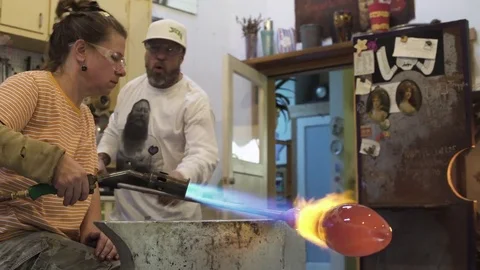 Medium shot of artisans heating glass with a blow torch Stock Footage 76226880
