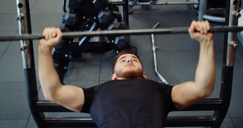 Medium shot of athletic handsome young man performing bench press in gym. Man 스톡 동영상 252814260