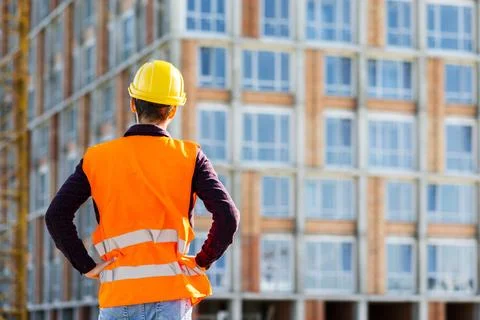 Medium shot back view engineer supervising construction Foto stock