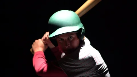 A medium shot of a baseball player swinging a bat with great intensity. Stock Footage 100076430