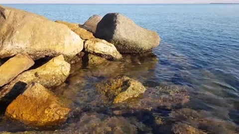 Medium shot between the rocks, calm sea, at sunrise Stock Footage 148512385