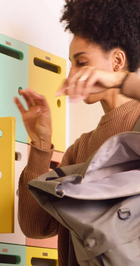 Medium shot of biracial student packing her books into backpack, campus locker Stock Footage 244580357