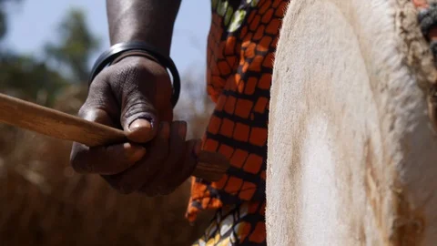 Medium shot of black man hand hitting skin of dundun with wooden stick Stock Footage 113119877