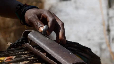Medium shot of black man hand playing kenken, metal ring on bell Stock Footage 113165897