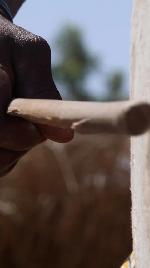 Medium shot of black man hand hitting skin of dundun with wooden stick Stock Footage 228843053