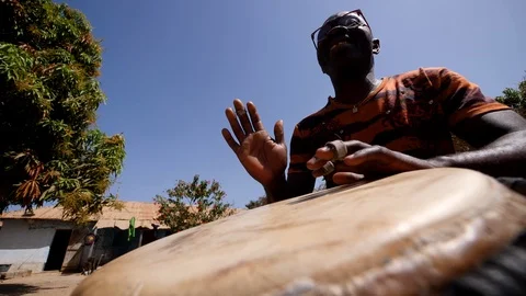 Medium shot of black man playing djembe with plaster on finger Stock Footage 113164972
