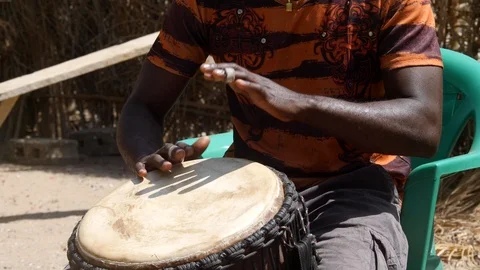 Medium shot of black man playing djembe with plaster on finger Video stock 113165099
