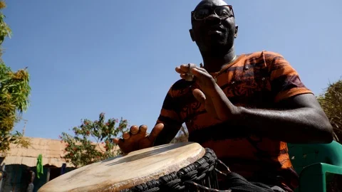 Medium shot of black man playing djembe with plaster on finger Video stock 113165625