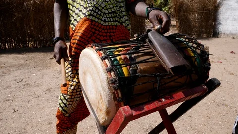 Medium shot of black man playing dundun and hitting metal ring on bell Video stock 113165878