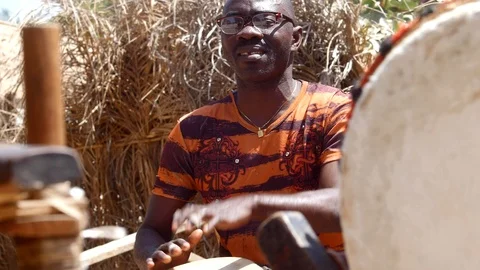 Medium shot of black man playing djembe with plaster on finger Video stock 113168114