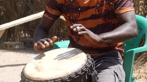 Medium shot of black man playing djembe with plaster on finger Stock Footage 113168133