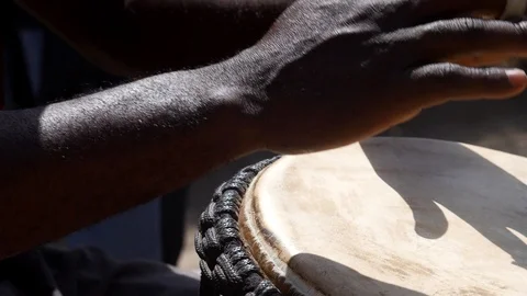 Medium shot of black man playing djembe with plaster on finger Video stock 113168271