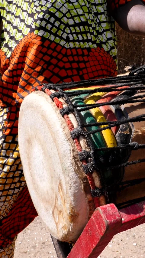 Medium shot of black man playing dundun and hitting metal ring on bell Stock-Footage 230663441