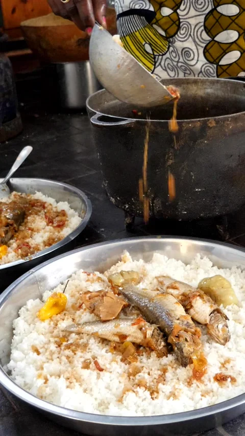Medium shot of black woman adding sauce to 3 big bowls of rice Stock Footage 230666872