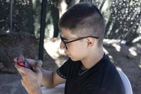 Medium shot of a boy playing an old red console Stock Photos