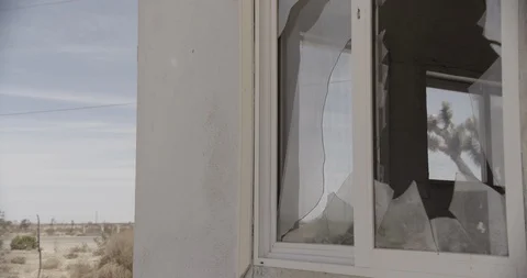 Medium Shot of Broken Window Pan Left to Desert Highway Stock Footage 89942124