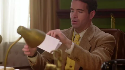 Medium shot of a businessman opens an envelope, 1960s, USA - Reenactment Stock Footage 245290551