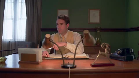 Medium shot of a businessman working at desk, 1960s, USA - Reenactment Stock Footage 245290549