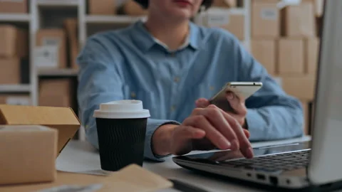 Medium shot of the camera, The girl looks at the phone and laptop, The emplo Stock Footage 219864295