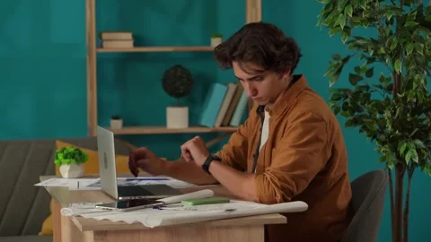 Medium shot capturing a man working in his home office, getting a phone call Stock Footage 260066419