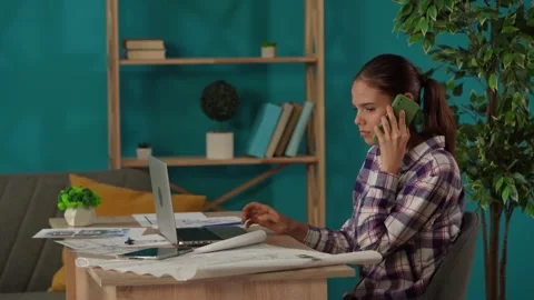 Medium shot capturing a woman working in her home office, getting a phone call Stock Footage 260065507