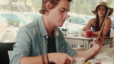 Medium shot of casual man using touch screen tablet computer in cafe. Stock Footage 199635051