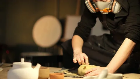 Medium shot of ceramic artist sanding teapot in the studio Stock Footage 236372374