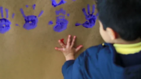 MEDIUM SHOT. Child put his hands painted in a wall in the kindergarten. Stock Footage 48441548