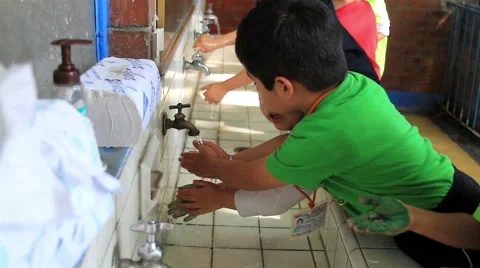 MEDIUM SHOT. Children whasing their hands in the  washbasin in the kindergarten. Stock Footage 48846476