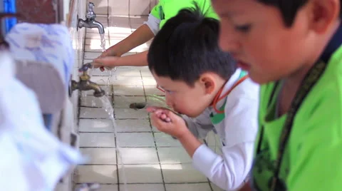 MEDIUM SHOT. Children whasing their hands in the  washbasin in the kindergarten. Stock Footage 48846654