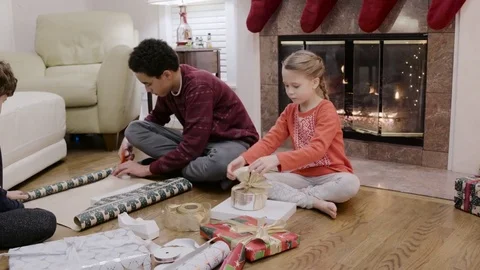 Medium shot of children wrapping a gift for Christmas 動画素材 73030230