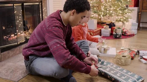 Medium shot of children wrapping a gift for Christmas 動画素材 73032743