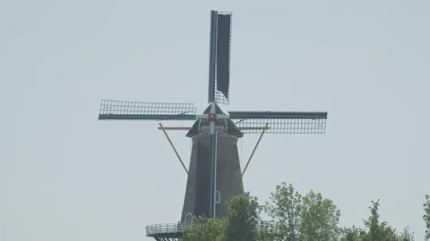 Medium shot of classical Dutch windmill with spinning blades. Tourists are 動画素材 157428119