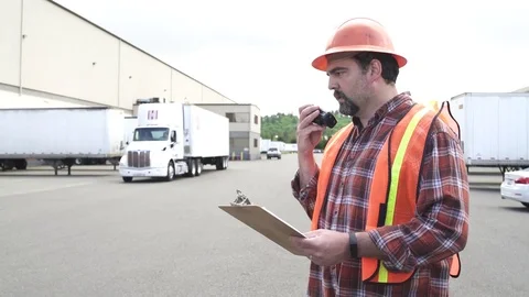 Medium shot of a control worker in a truck parking lot 動画素材 76224435