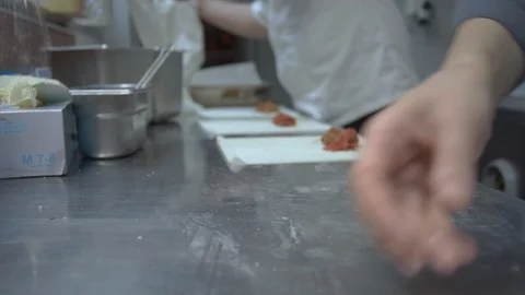 Medium shot of cooks rolling springrolls Stock Footage 102336179