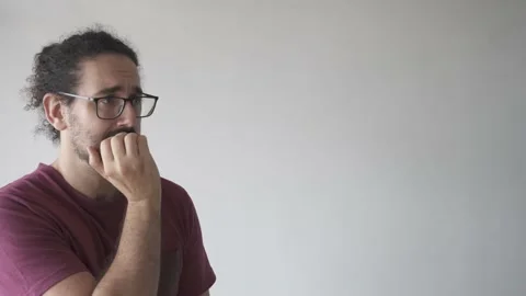 Medium shot with copy space of anxious young man biting his nails Stock Footage 161551948