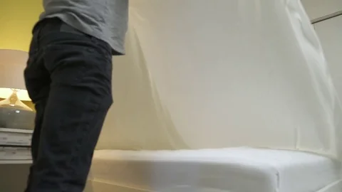 Medium shot of a couple changing sheet on a bed Stock Footage 76235344