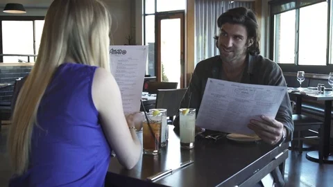 Medium shot of a couple reading menu in a restaurant Stock-Footage 76235079