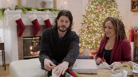 Medium shot of a couple wrapping a gift for Christmas 動画素材 73037494